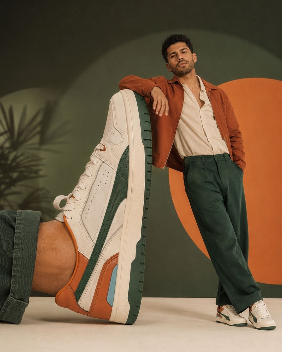 Editorial de tênis criado com IA: modelo apoiado em um tênis gigante em cenário verde e laranja
